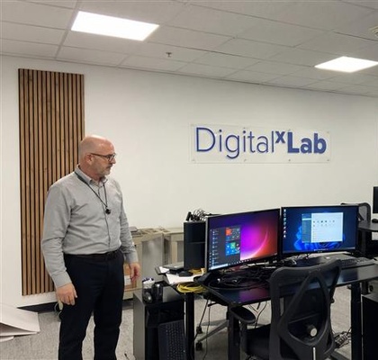 Abel in a digital lab environment with monitors and workstations supporting digital consulting activities.