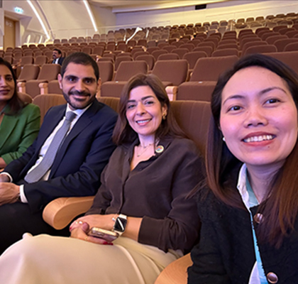 Enrica sitting with three colleagues in an auditorium.