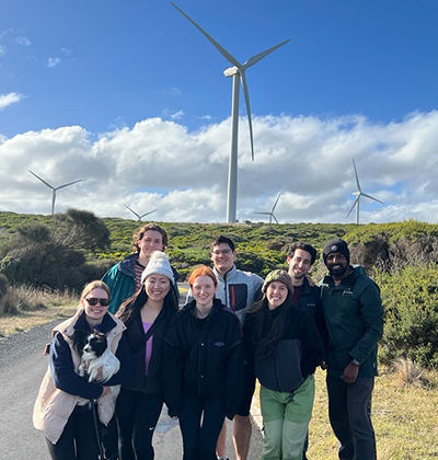 Helene with her colleagues standing together wind turbines in the background.