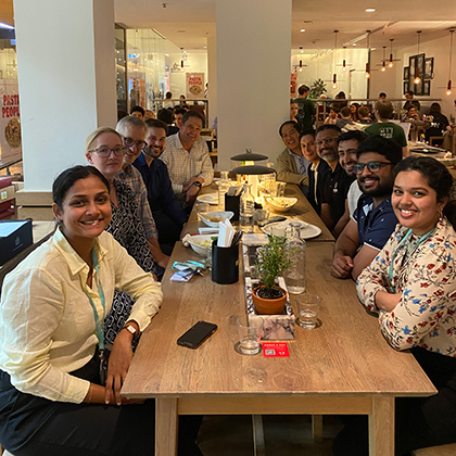 Josh at a restaurant table with a group of colleagues.
