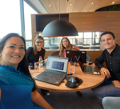 Juanita sitting around a table working with 3 colleagues.