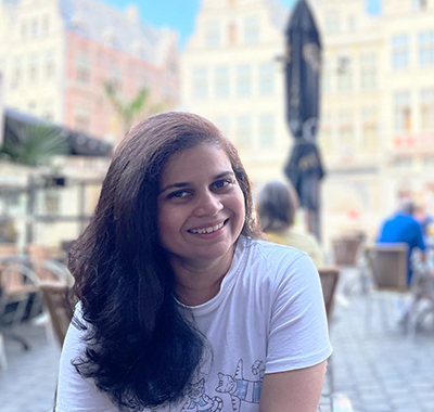 Madhura Parab of Worley sitting at a cafe in city square in Ghent.
