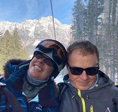Nicola and husband on a ski chair lift in the mountains.