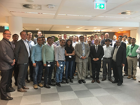 Shripad standing with a large group of people of Worley inside the office.