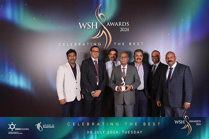 Yogesh standing with six colleagues at award ceremony.