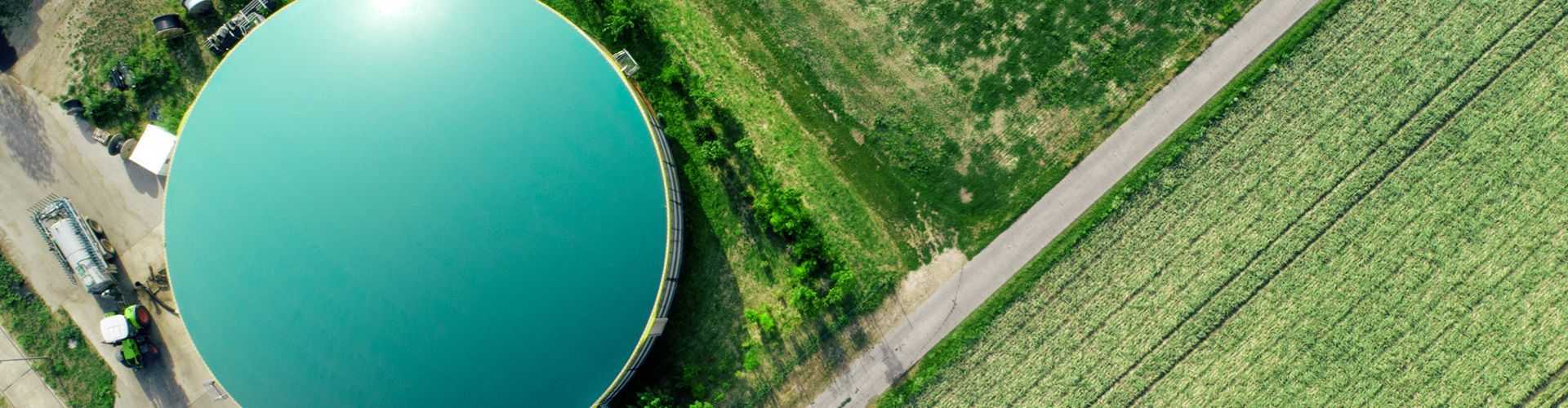 Aerial view of a biogas plant surrounded by greenery.