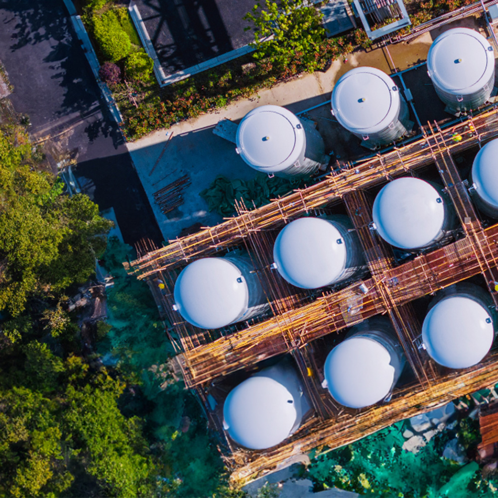 Aerial view of rows of tanks at a plant.