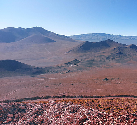 View across the project open pit area, with exposed rock formations and surrounding high-altitude terrain.