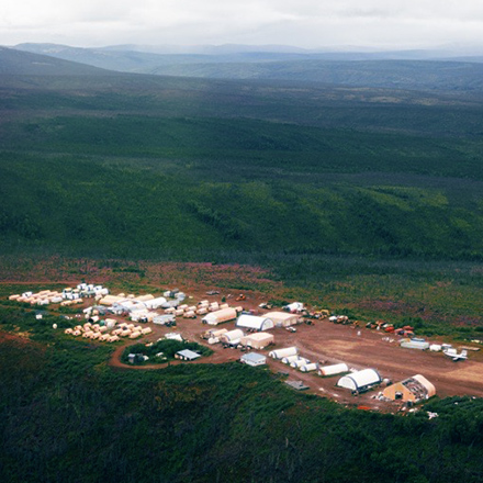 Aerial view of the camp at the Donlin Gold project surrounded by trees and mountains.