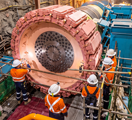 People wearing PPE working on mining machinery.