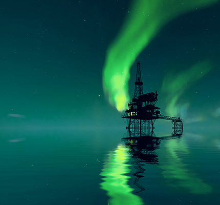 Silhouette of an offshore oil platform with the green Northern Lights in background.