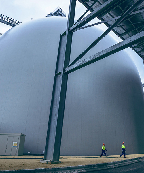 Two workers walking through a biomass facility.