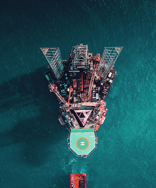 Aerial view of an offshore oil platform next to a ship.