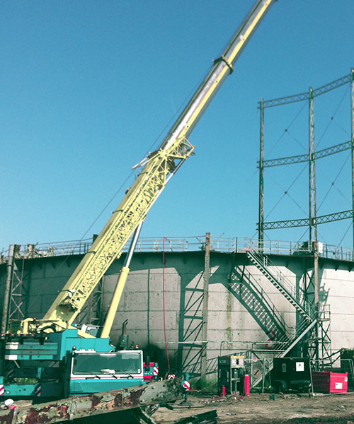 Gas holder being dismantled with cranes during the decommissioning process.