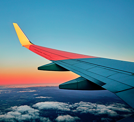 Wing of an airplane flying above the Earth.