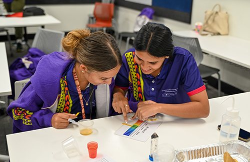 Two girls at a desk doing water testing.