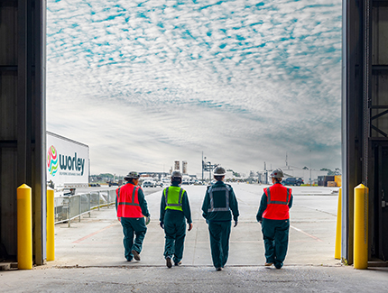 Four Worley trade and craft women walking in a line out of a factory.