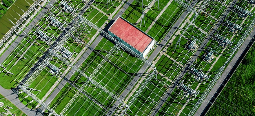 Aerial view of an electrical substation and transmission infrastructure.