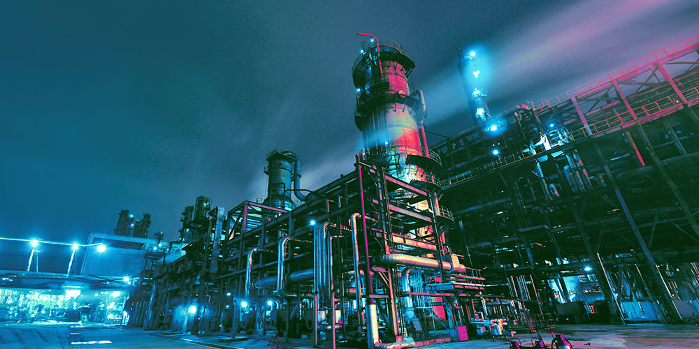 Refinery plant at night with bright lights.