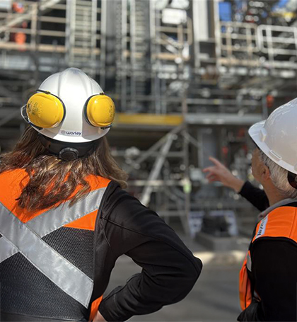 Andrea and a colleague looking up at a large steel structure.