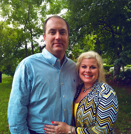 Andy with his partner outside under trees.
