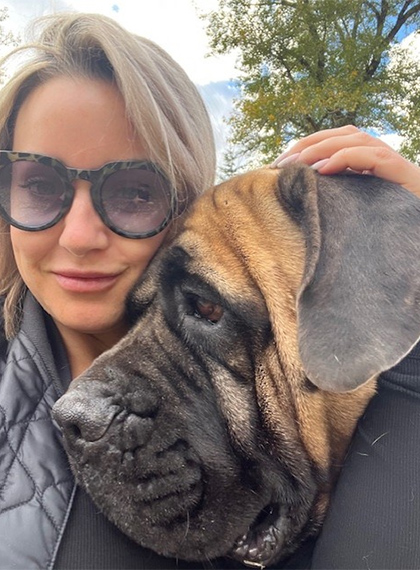 Cheryl leaning against a large dog.