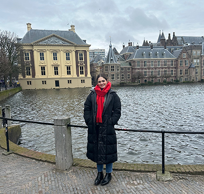 Harriet standing in front of the water with buildings in background in The Hague.