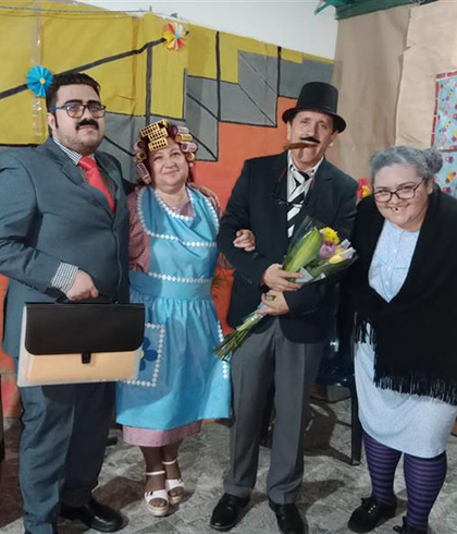 Juan in costume on a theatre set with three other actors.