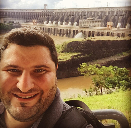Leandro standing in front of a large hydropower plant.