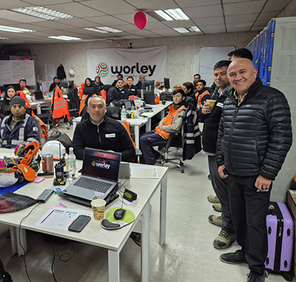 Manuel standing in a big room with seated employees in a site office.
