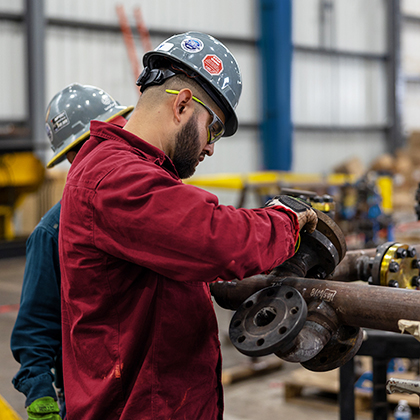 Worley trade and craft worker working on machinery.