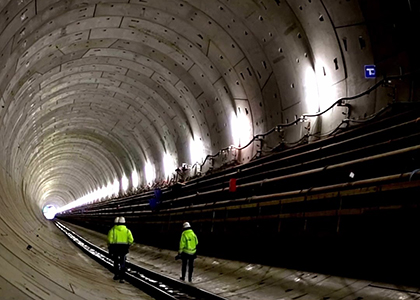 Three workers walking in an underground tunnel.