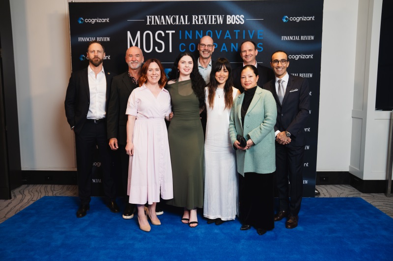 Group of nine Worley people standing in front of an awards banner.
