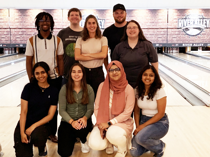 Group of Worley graduates standing together at a Tenpin bowling alley.