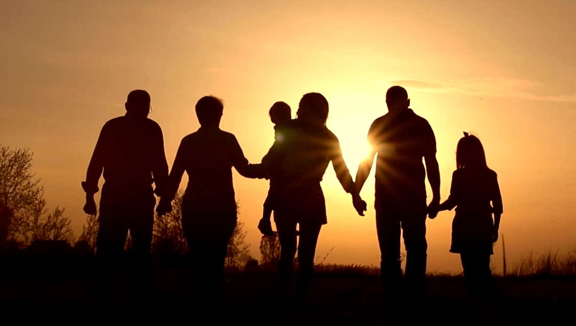 Silhouette of a family of 6 people walking hand in hand.