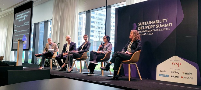 Neera from Worley Consulting sitting on a panel on stage.