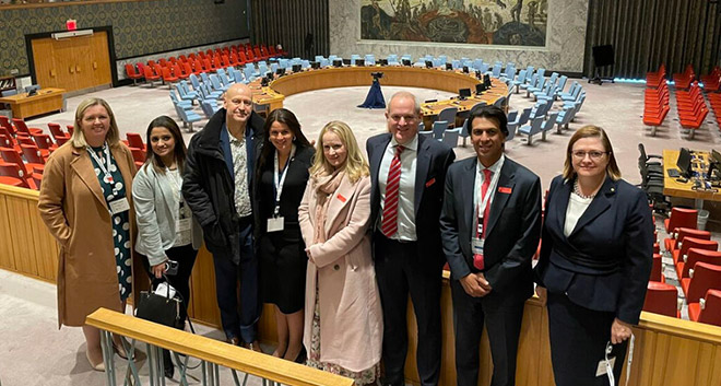 Gillian standing with a groupo of 7 others inside the UN's Security Council Chamber.