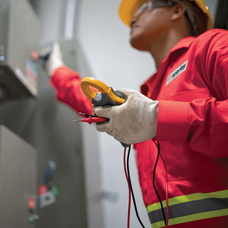 Worley person wearing PPE pulling a lever on a machine.