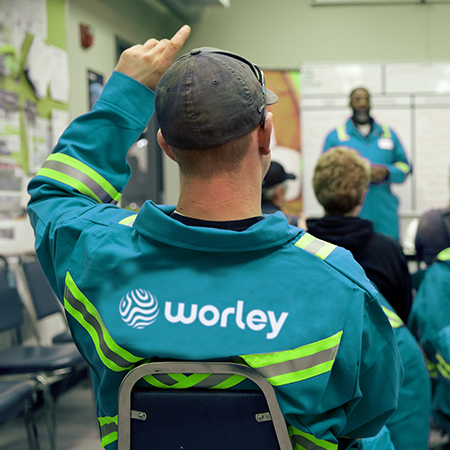 Group of Worley people sitting in a room listening to a speaker at the front.